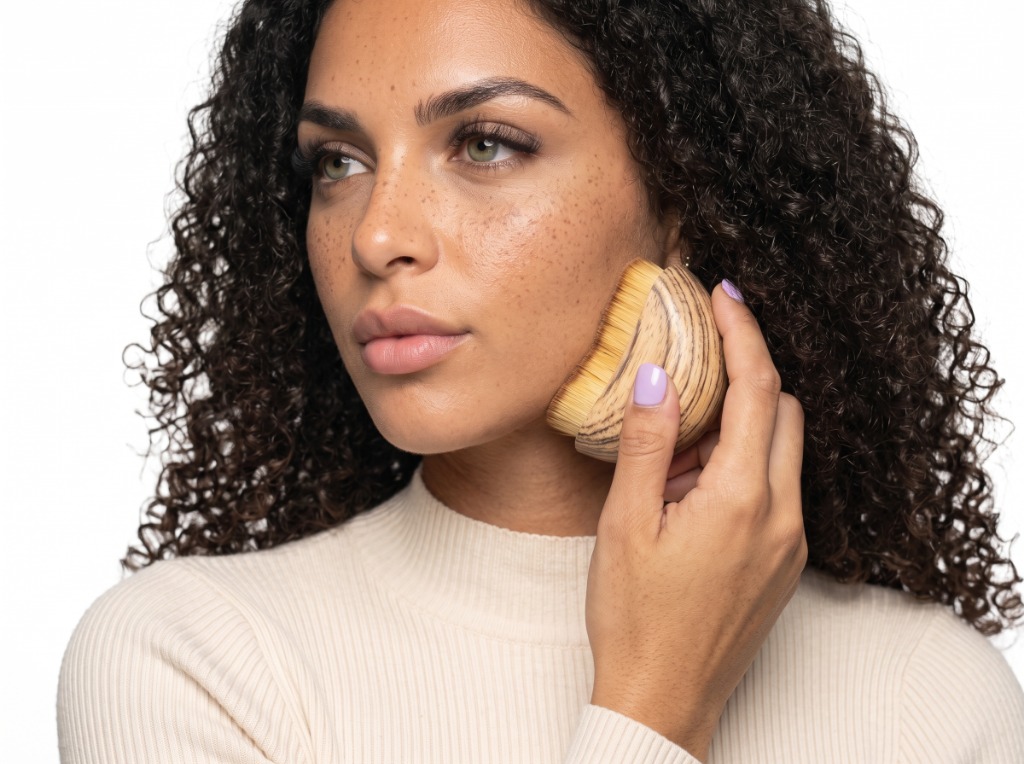 Woman using the premium DrainFace sonic lymphatic drainage brush